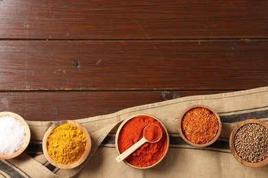 Photo of Different aromatic spices on wooden table, flat lay. Space for text