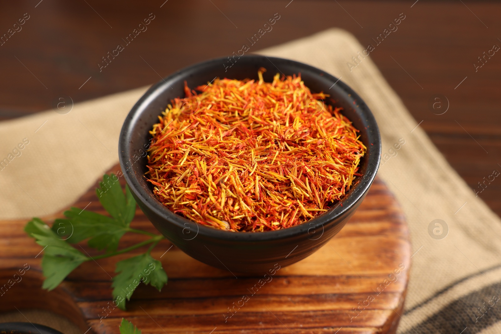 Saffron in bowl and coriander on table, closeup. Aromatic spices Photo of Saffron in bowl and coriander on table, closeup. Aromatic spices