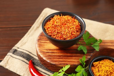 Photo of Different aromatic spices on wooden table, closeup
