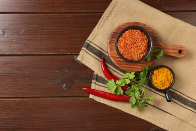 Photo of Different aromatic spices on wooden table, flat lay. Space for text