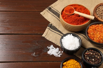 Photo of Different aromatic spices on wooden table. Space for text