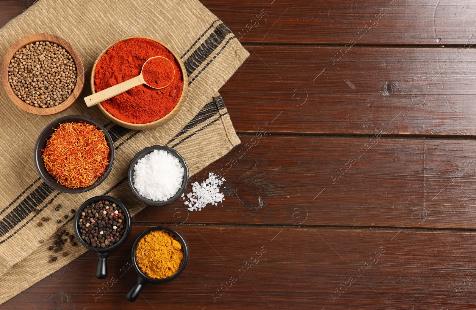 Photo of Different aromatic spices on wooden table, flat lay. Space for text