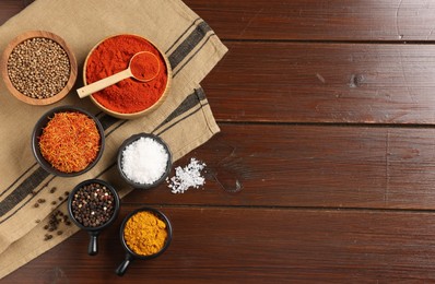 Photo of Different aromatic spices on wooden table, flat lay. Space for text