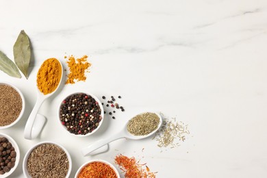 Photo of Different aromatic spices on white marble table, flat lay. Space for text