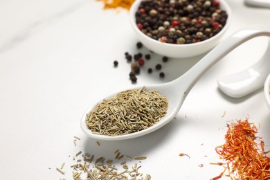 Photo of Different aromatic spices on white marble table, closeup. Space for text