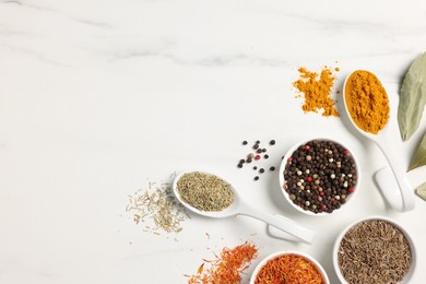 Photo of Different aromatic spices on white marble table, flat lay. Space for text