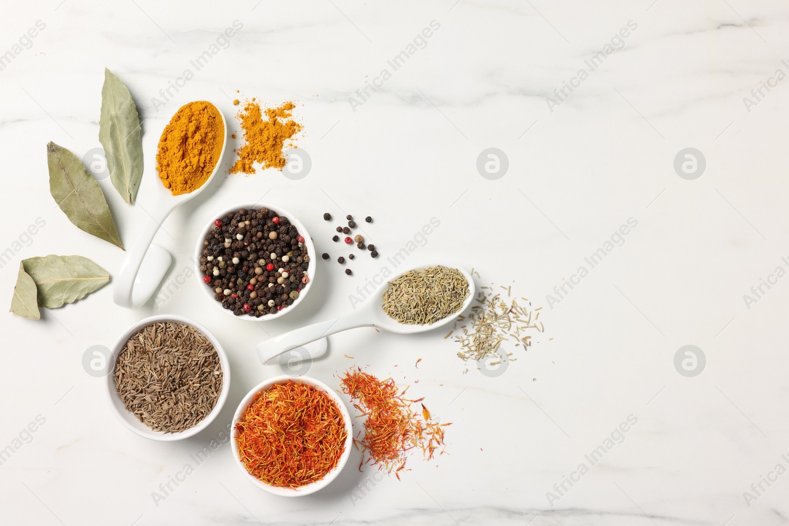 Photo of Different aromatic spices on white marble table, flat lay. Space for text