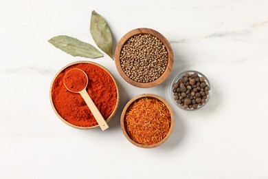 Photo of Different aromatic spices on white marble table, flat lay