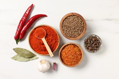 Photo of Different aromatic spices on white marble table, flat lay