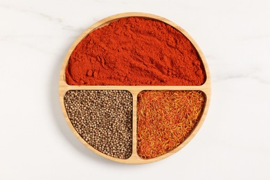 Photo of Different aromatic spices on white marble table, top view