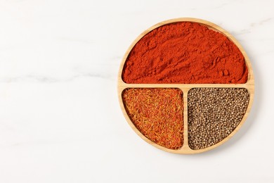 Photo of Different aromatic spices on white marble table, top view. Space for text