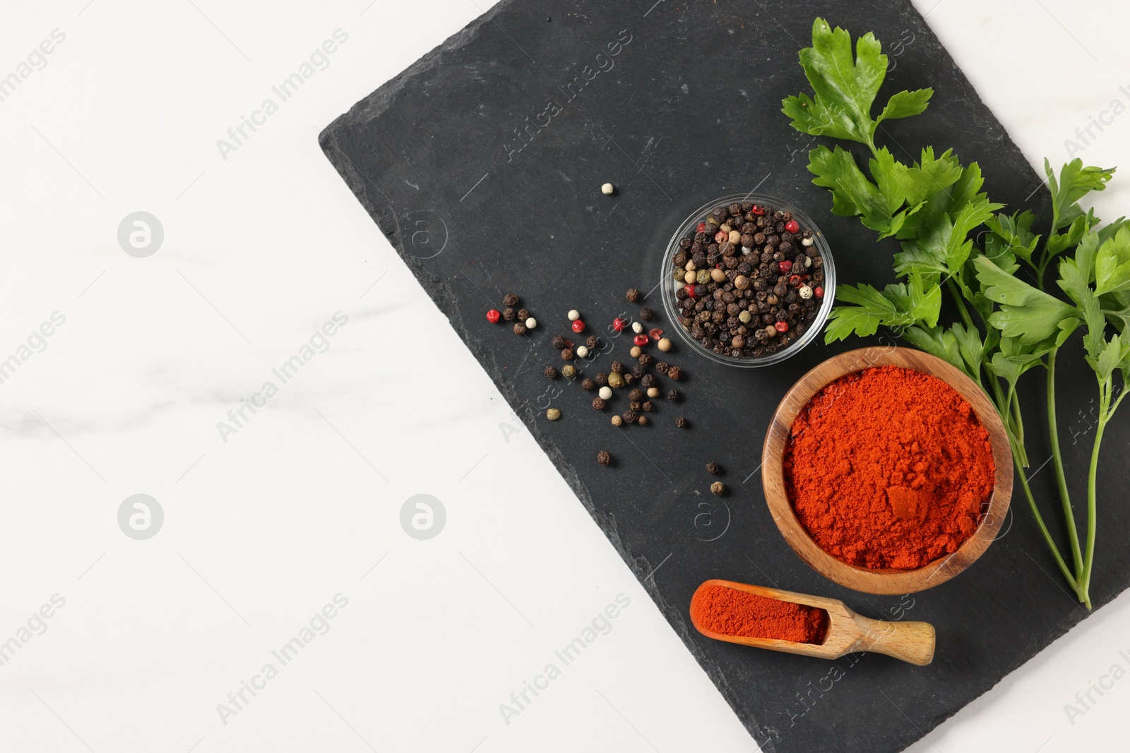 Photo of Different aromatic spices on white marble table, top view. Space for text