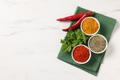 Photo of Different aromatic spices on white marble table, top view. Space for text