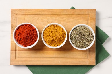 Photo of Different aromatic spices on white marble table, top view