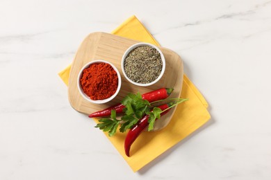 Photo of Different aromatic spices on white marble table, top view