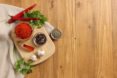 Photo of Different aromatic spices on wooden table, flat lay. Space for text