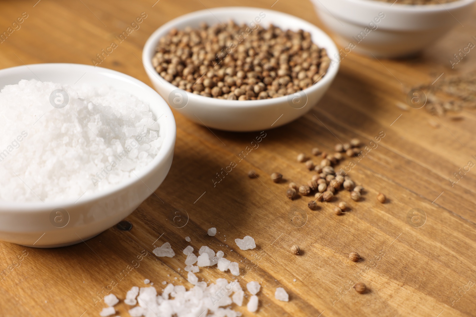 Photo of Different aromatic spices on wooden table, closeup