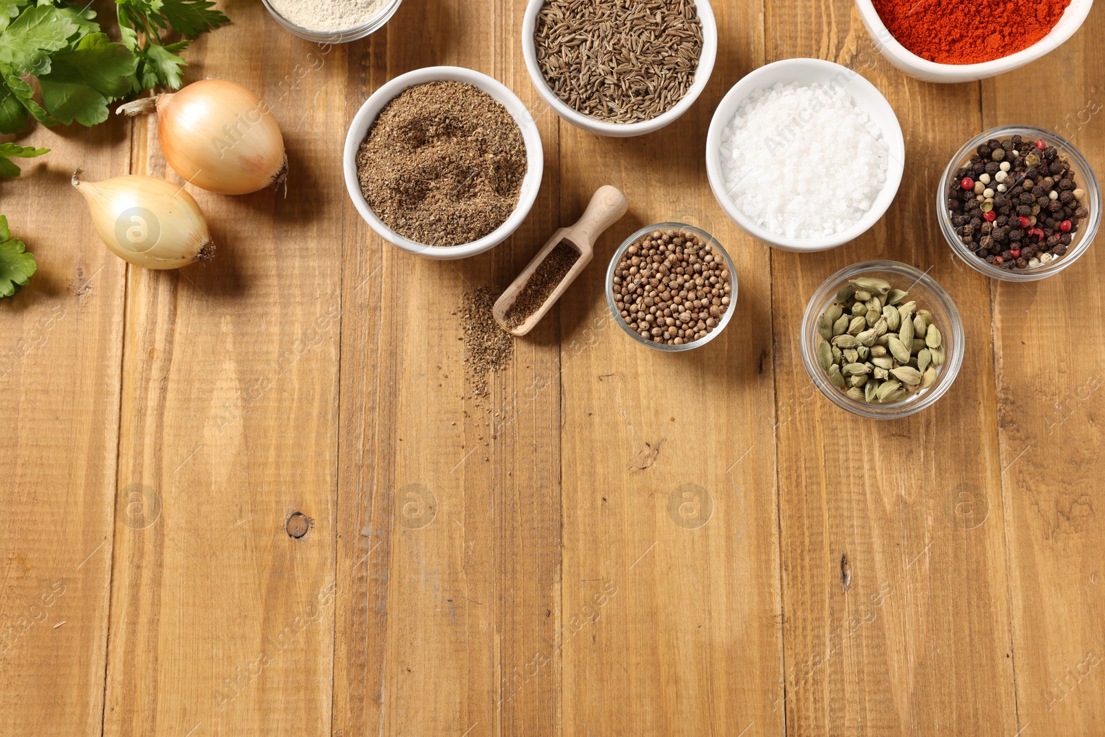 Photo of Different aromatic spices on wooden table, flat lay. Space for text