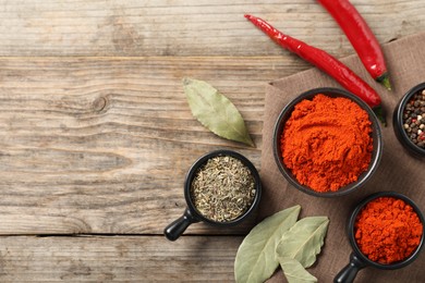 Photo of Different aromatic spices on wooden table, flat lay. Space for text