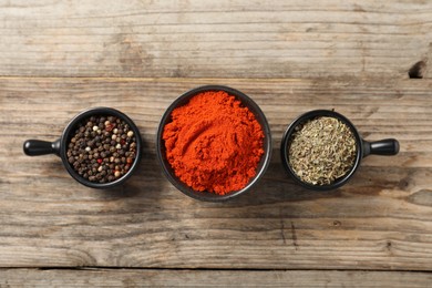 Photo of Different aromatic spices on wooden table, flat lay