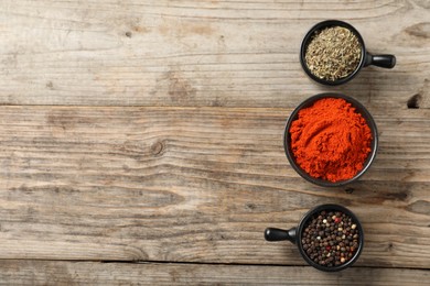 Photo of Different aromatic spices on wooden table, flat lay. Space for text