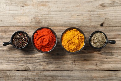 Photo of Different aromatic spices on wooden table, flat lay