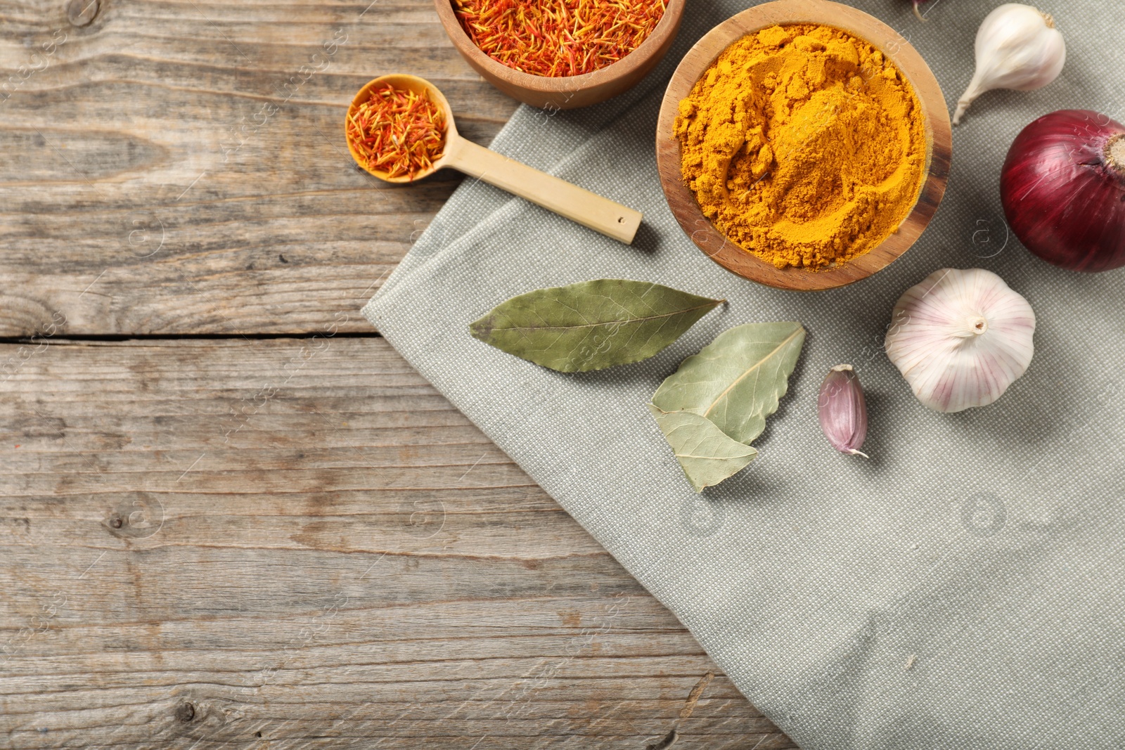 Photo of Different aromatic spices on wooden table, flat lay. Space for text
