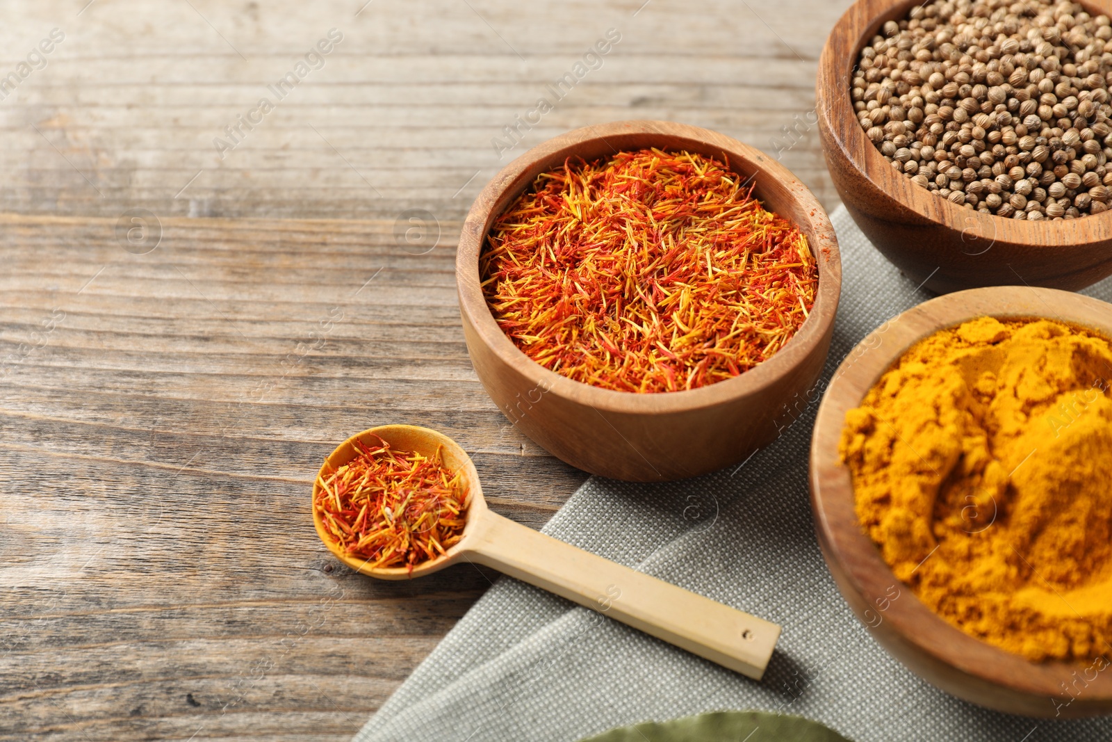 Photo of Different aromatic spices on wooden table, closeup. Space for text