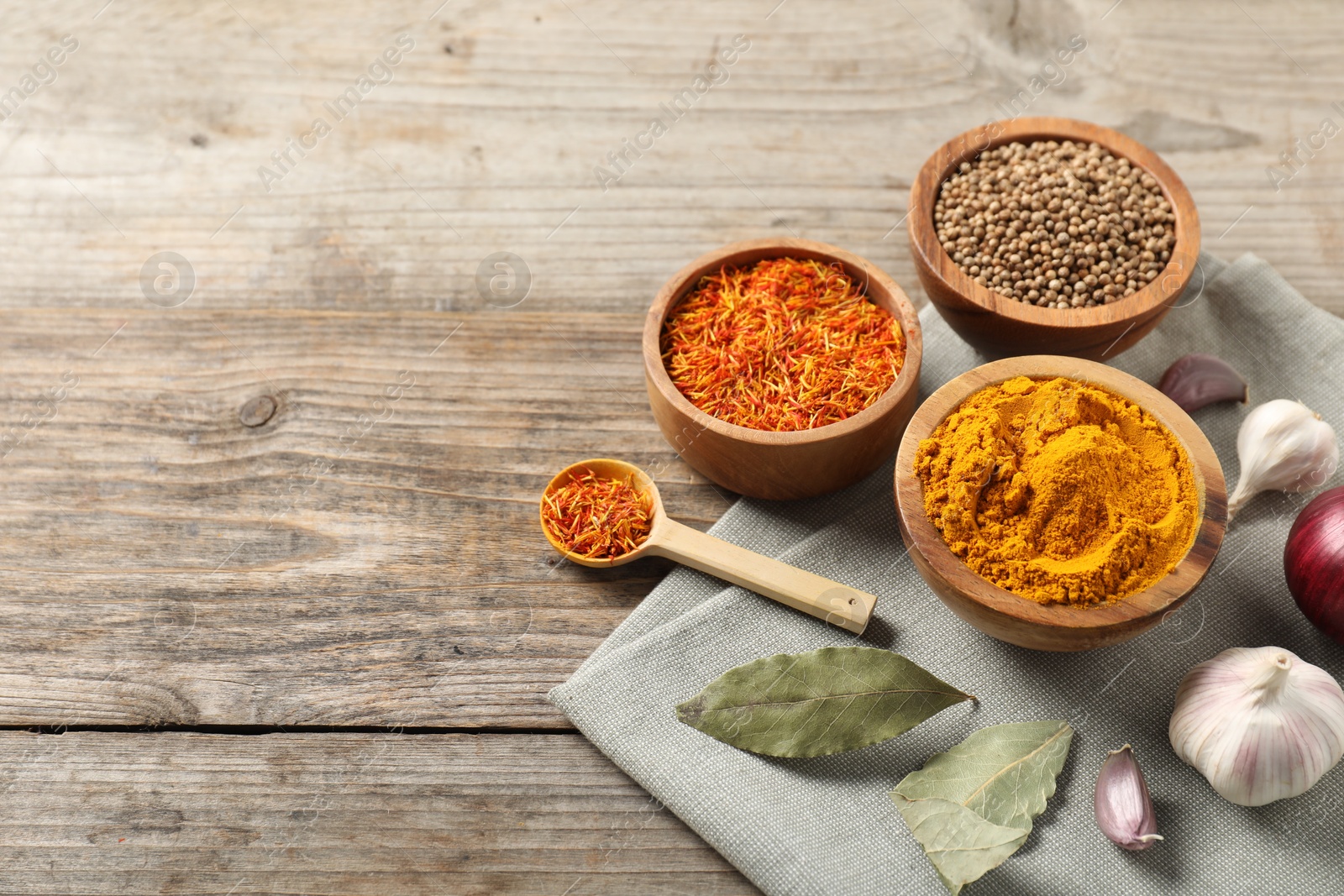 Photo of Different aromatic spices on wooden table. Space for text