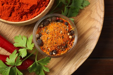 Photo of Different aromatic spices on wooden table, top view