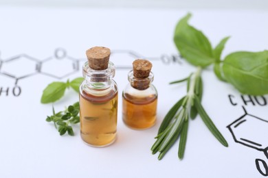 Photo of Different herbs and bottles of cosmetic products on paper with chemical formulas, closeup