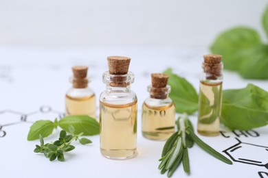 Photo of Different herbs and bottles of cosmetic products on paper with chemical formulas, closeup