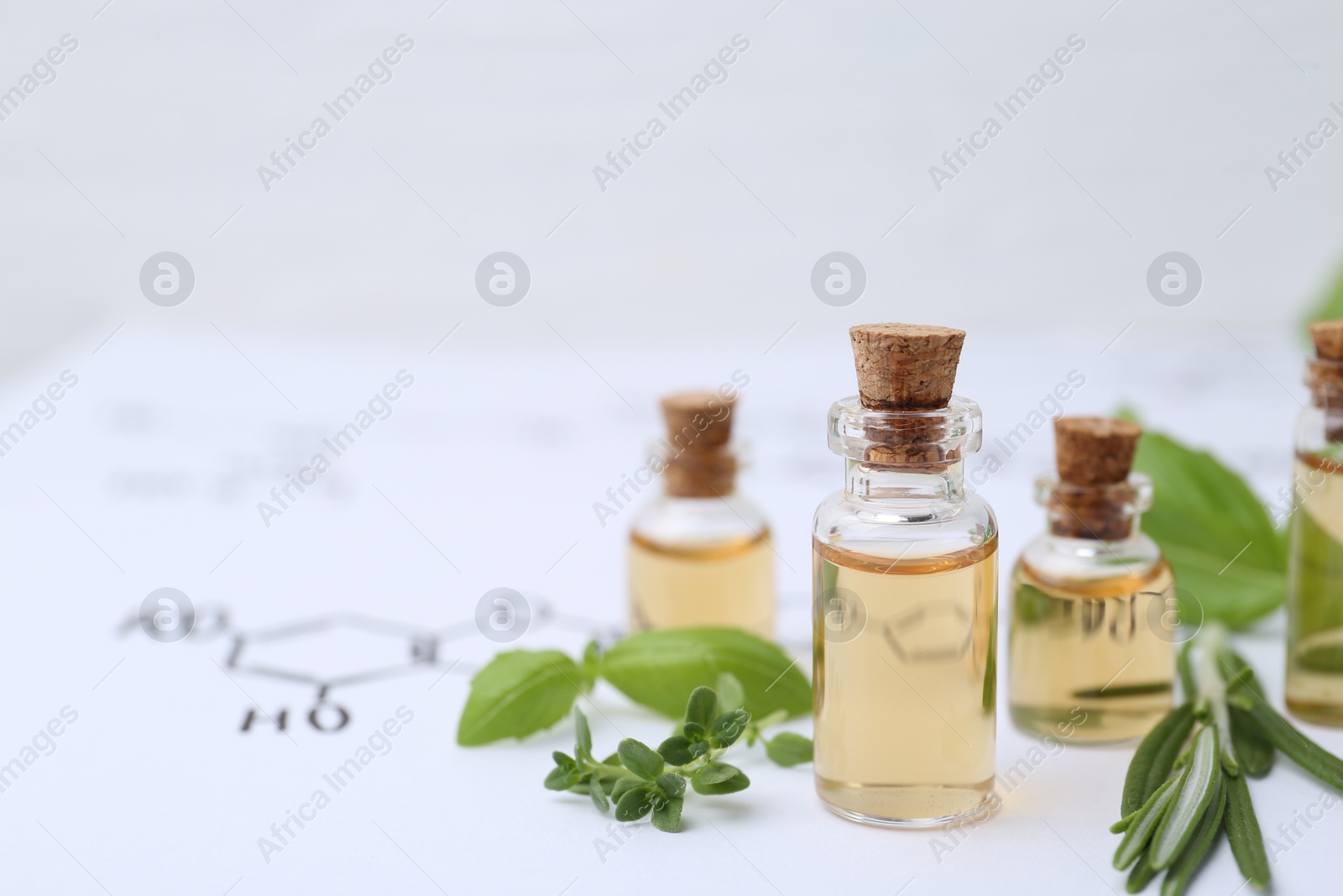 Different herbs and bottles of cosmetic products on paper with chemical formulas, closeup. Space for text Photo of Different herbs and bottles of cosmetic products on paper with chemical formulas, closeup. Space for text
