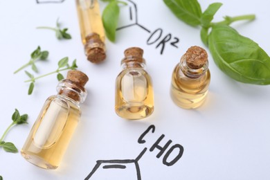Photo of Different herbs and bottles of cosmetic products on paper with chemical formulas, above view