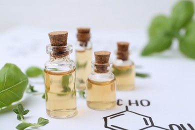 Photo of Different herbs and bottles of cosmetic products on paper with chemical formulas, closeup. Space for text