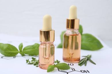 Photo of Different herbs and bottles of cosmetic products on paper with chemical formulas, closeup