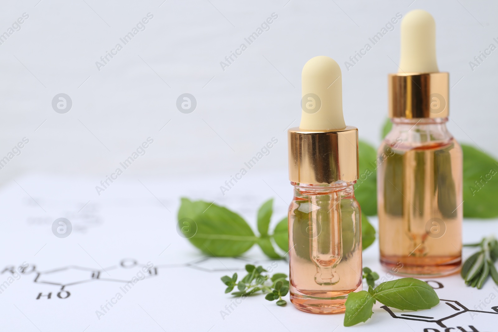Different herbs and bottles of cosmetic products on paper with chemical formulas, closeup. Space for text Photo of Different herbs and bottles of cosmetic products on paper with chemical formulas, closeup. Space for text
