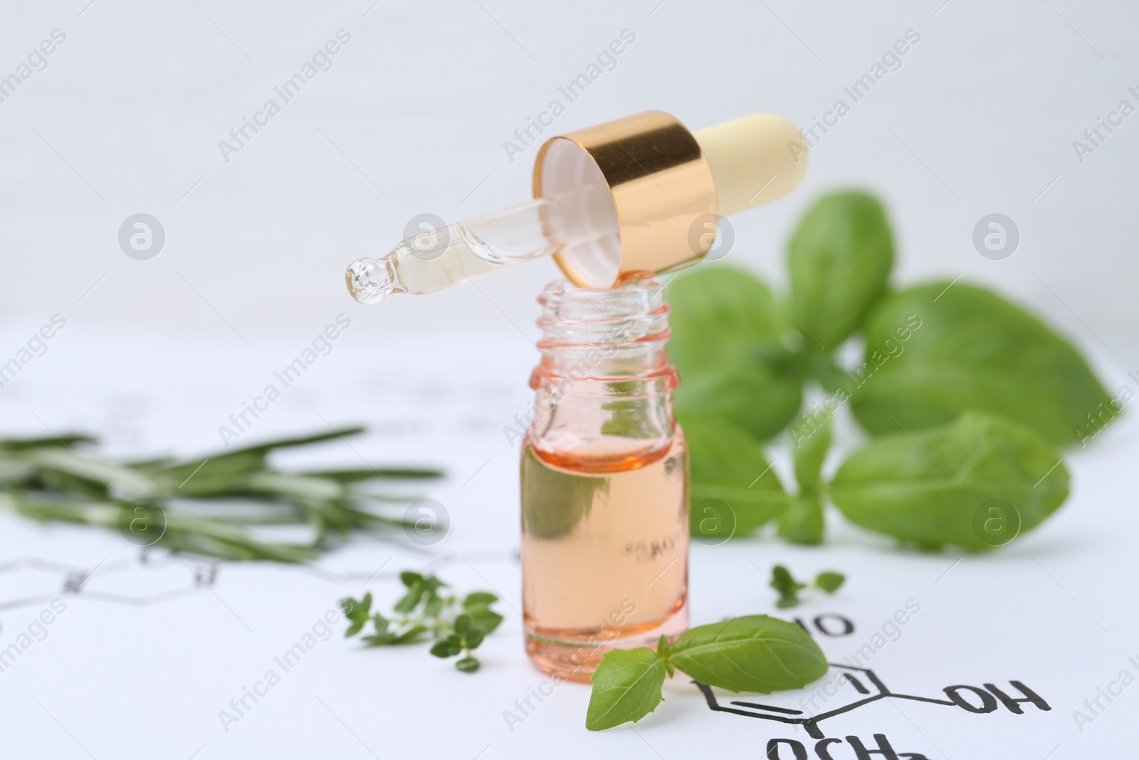 Different herbs and bottle of cosmetic product on paper with chemical formulas, closeup Photo of Different herbs and bottle of cosmetic product on paper with chemical formulas, closeup