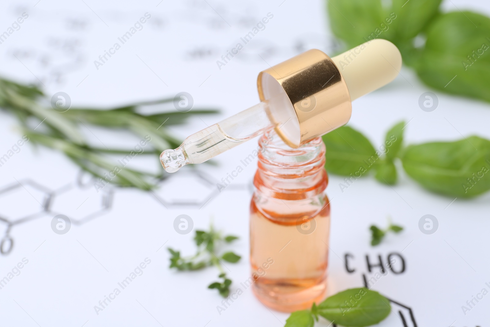 Different herbs and bottle of cosmetic product on paper with chemical formulas, closeup Photo of Different herbs and bottle of cosmetic product on paper with chemical formulas, closeup