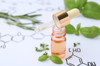 Photo of Different herbs and bottle of cosmetic product on paper with chemical formulas, closeup