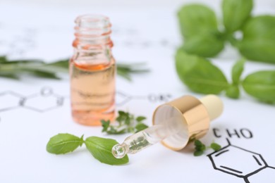 Photo of Different herbs and bottle of cosmetic product on paper with chemical formulas, closeup