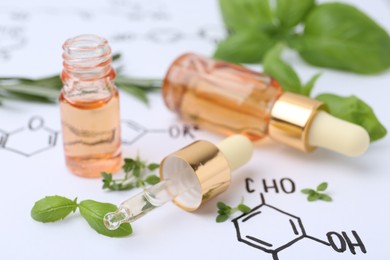 Photo of Different herbs and bottles of cosmetic products on paper with chemical formulas, closeup