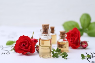 Photo of Bottles of cosmetic products, herbs and red roses on paper with chemical formulas, closeup
