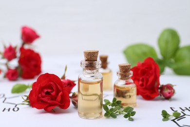 Photo of Bottles of cosmetic products, herbs and red roses on paper with chemical formulas, closeup