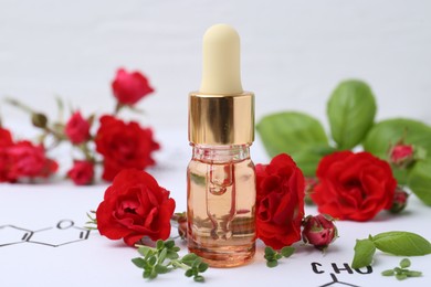Photo of Bottle of cosmetic product, herbs and red roses on paper with chemical formulas, closeup