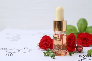 Photo of Bottle of cosmetic product, herbs and red roses on paper with chemical formulas, closeup. Space for text