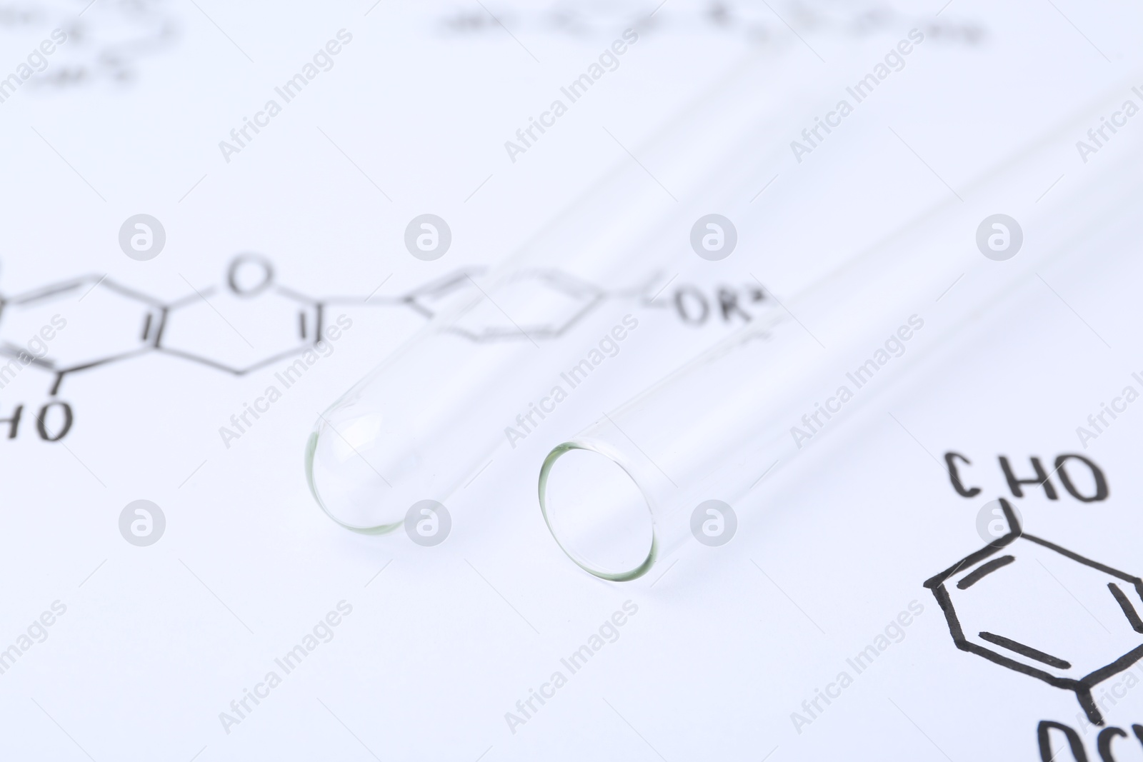 Test tubes on paper with chemical formulas, closeup Photo of Test tubes on paper with chemical formulas, closeup