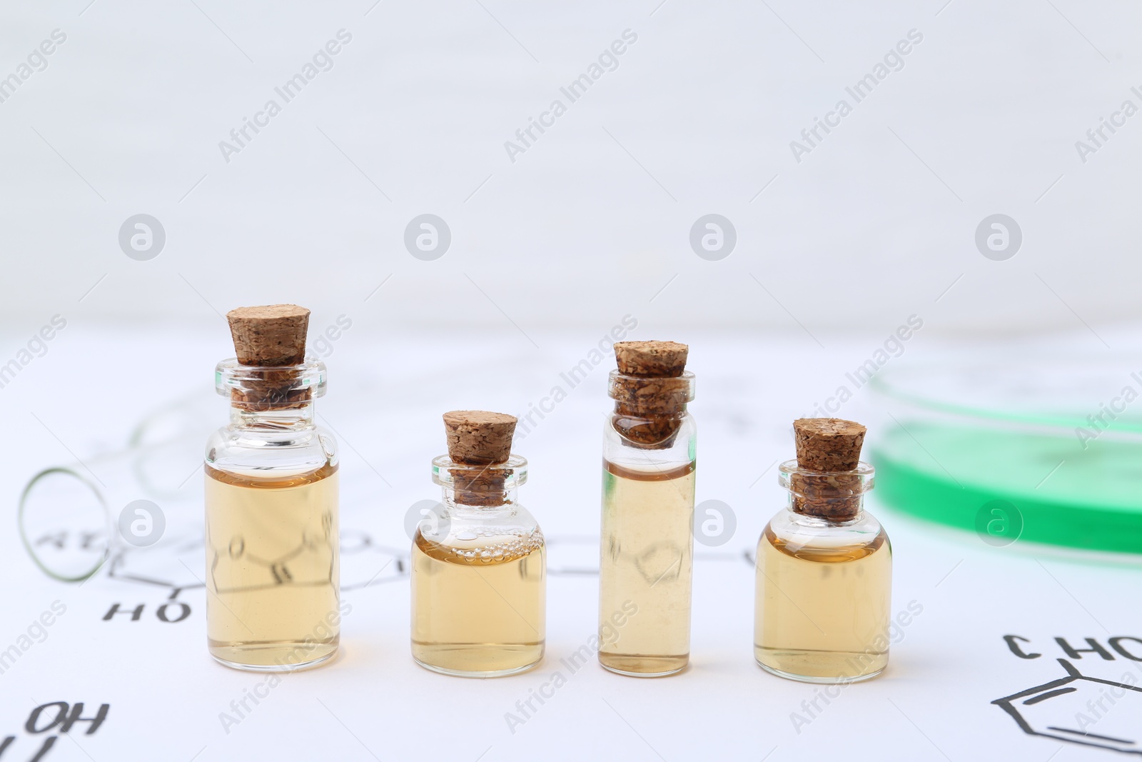 Bottles of cosmetic products, test tube and Petri dish of sample on paper with chemical formulas, closeup Photo of Bottles of cosmetic products, test tube and Petri dish of sample on paper with chemical formulas, closeup