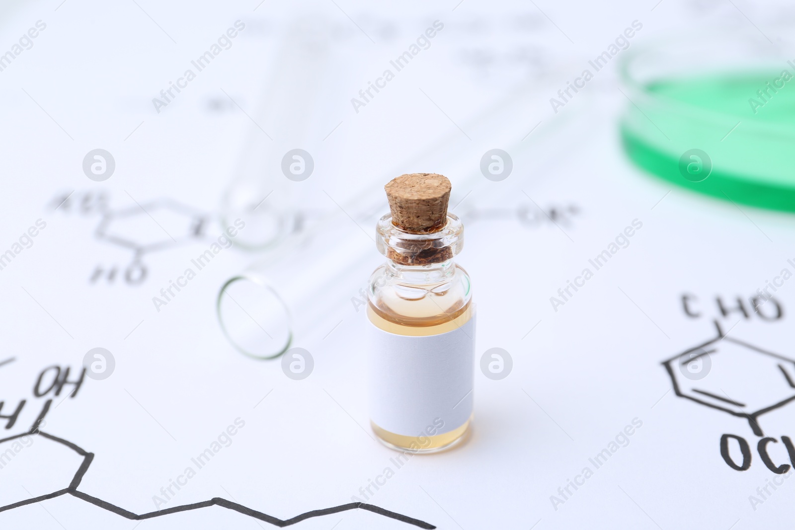 Bottle of cosmetic product, test tubes and Petri dish of sample on paper with chemical formulas, closeup Photo of Bottle of cosmetic product, test tubes and Petri dish of sample on paper with chemical formulas, closeup