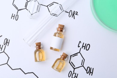 Photo of Bottles of cosmetic products, test tubes and Petri dish of sample on paper with chemical formulas, flat lay